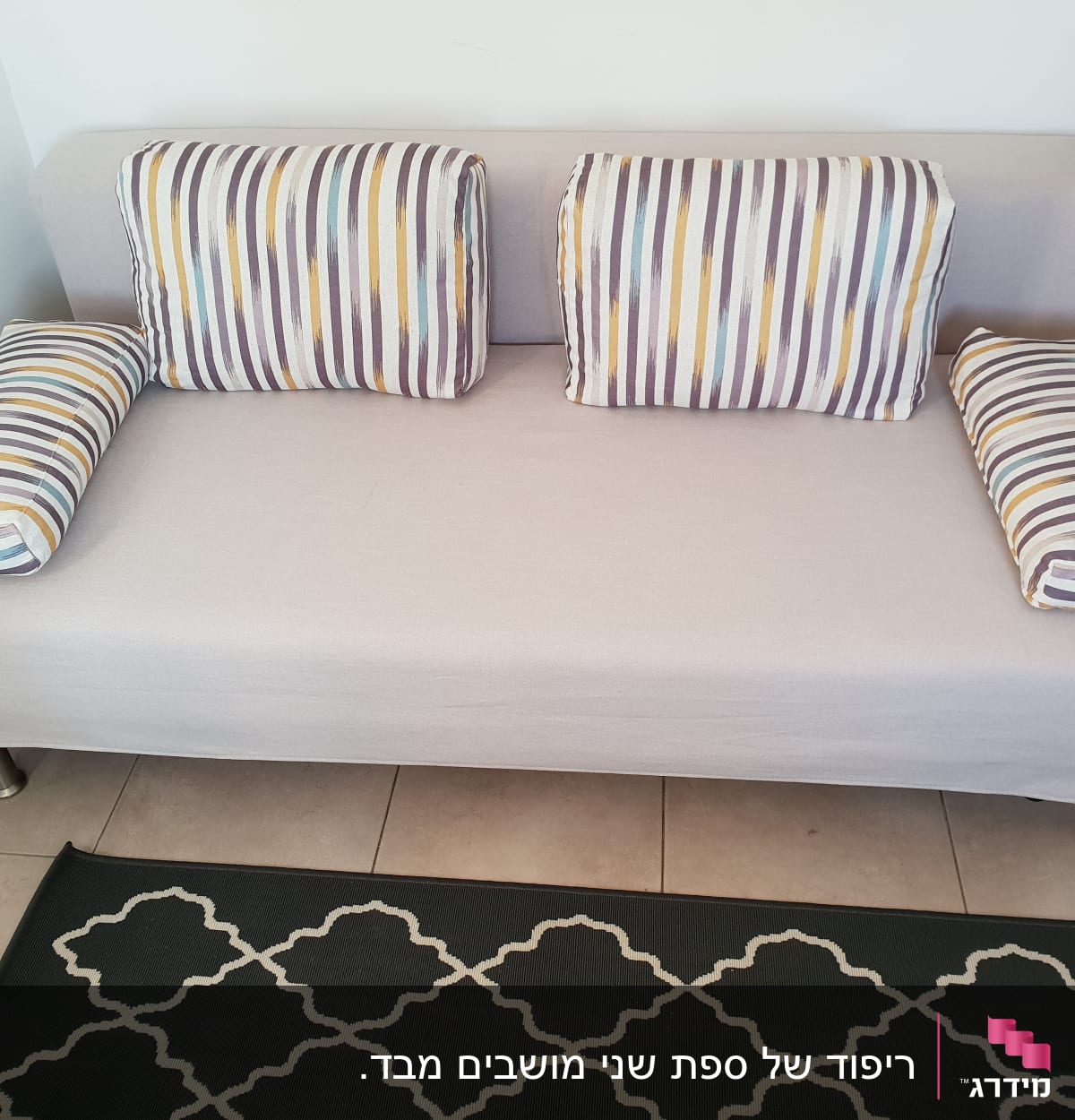 כריות פסים צבעוניות על ספה אפורה